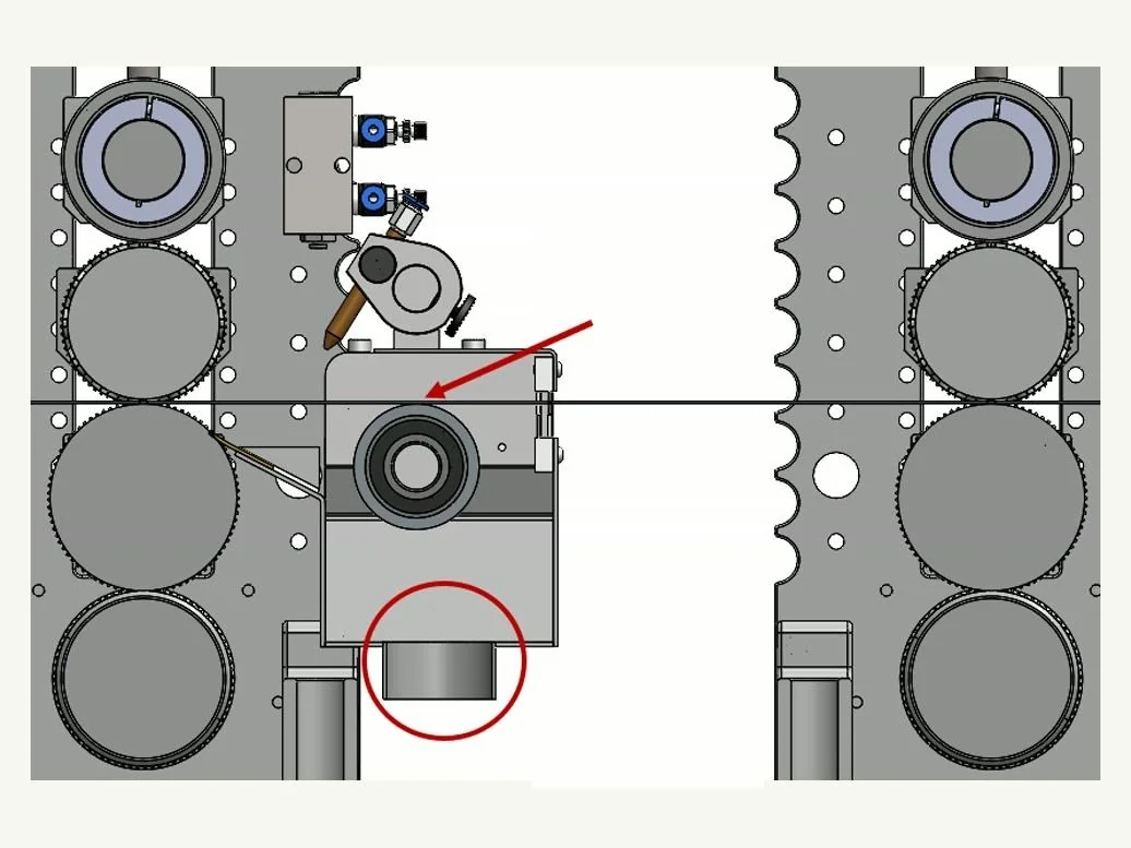 Vista frontal: la banda pasa tangente a la boca del extractor y la aspiración se conecta por debajo