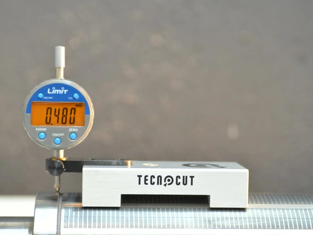 Reloj comparador del medidor de cilindros Tecnocut apoyado sobre un cilindro de troquelado